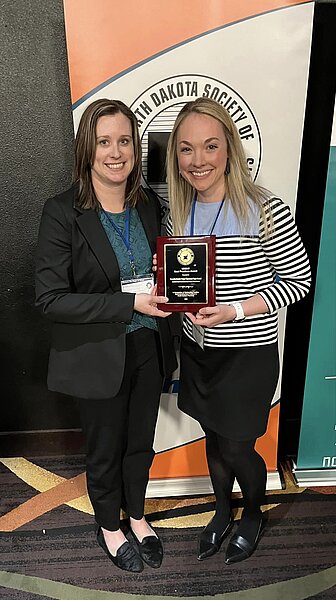 Photo of Dr. Amanda Meyer receiving a plaque from ND Society of Health-System Pharmacists for Controlled Substances Best Practice Award