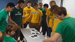 students looking at the parts of a cubesat