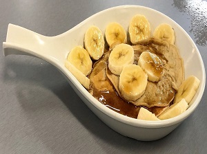 Pancakes Topped with Sliced Bananas and Syrup