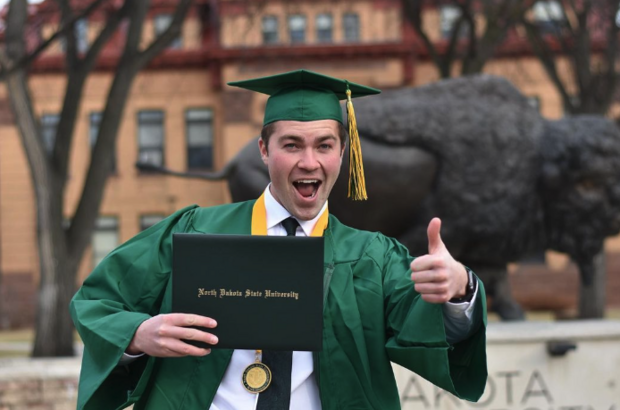 Commencement Student In Front of Bison Statue