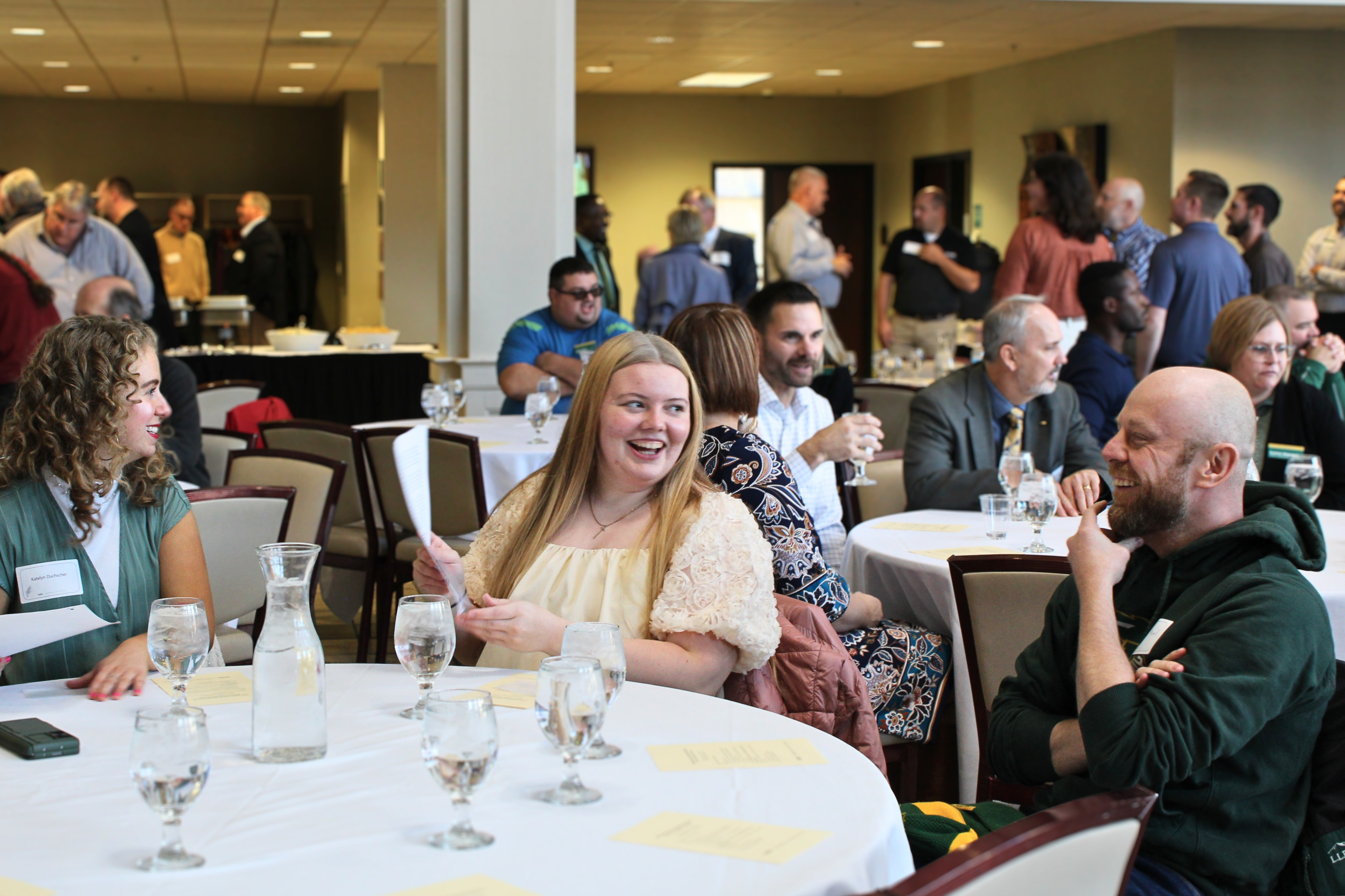 People smiling during conversation at a lunch round table