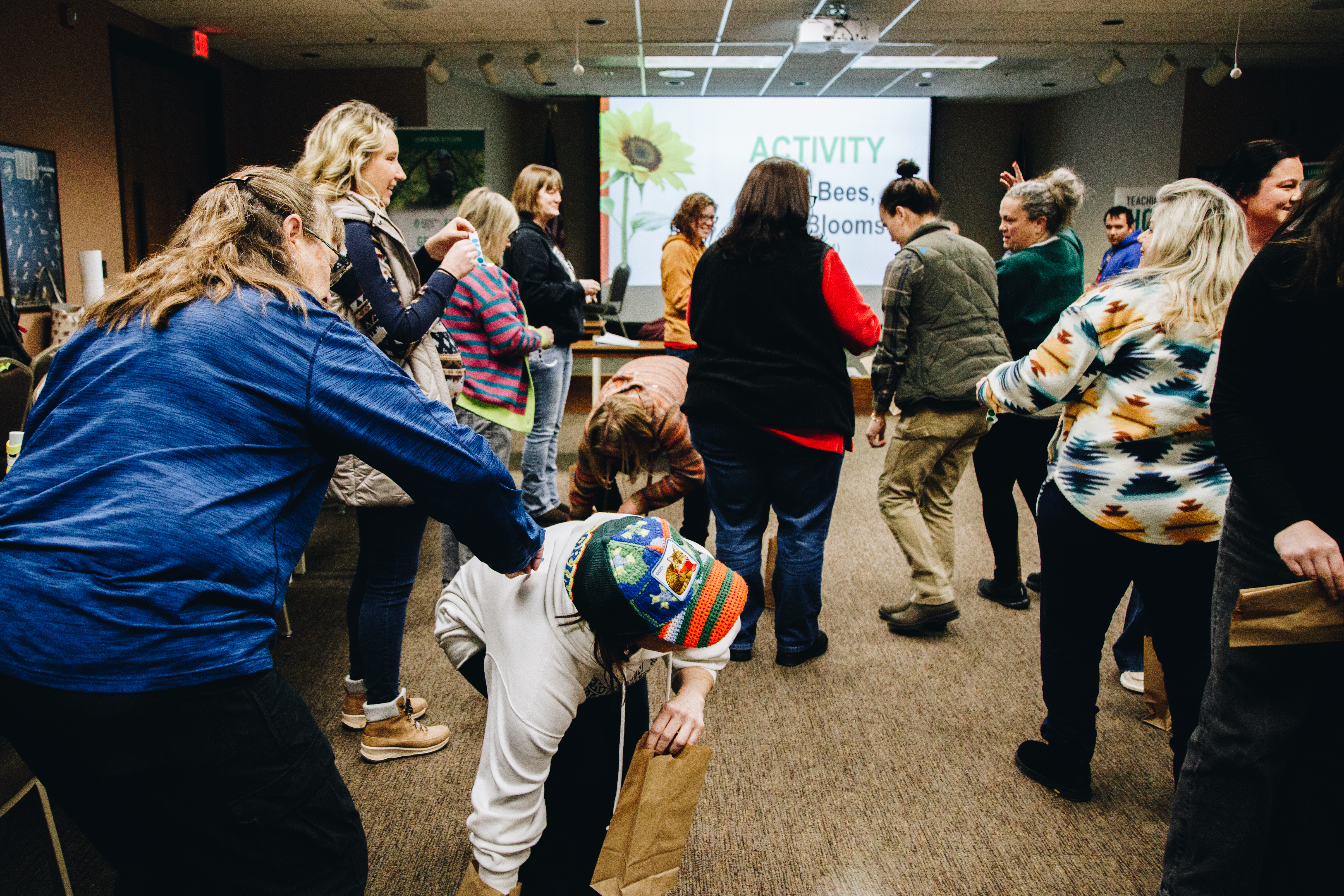 A group of people play a game where they emulate how pollinators collect nectar from flowers and how flowers share their pollen