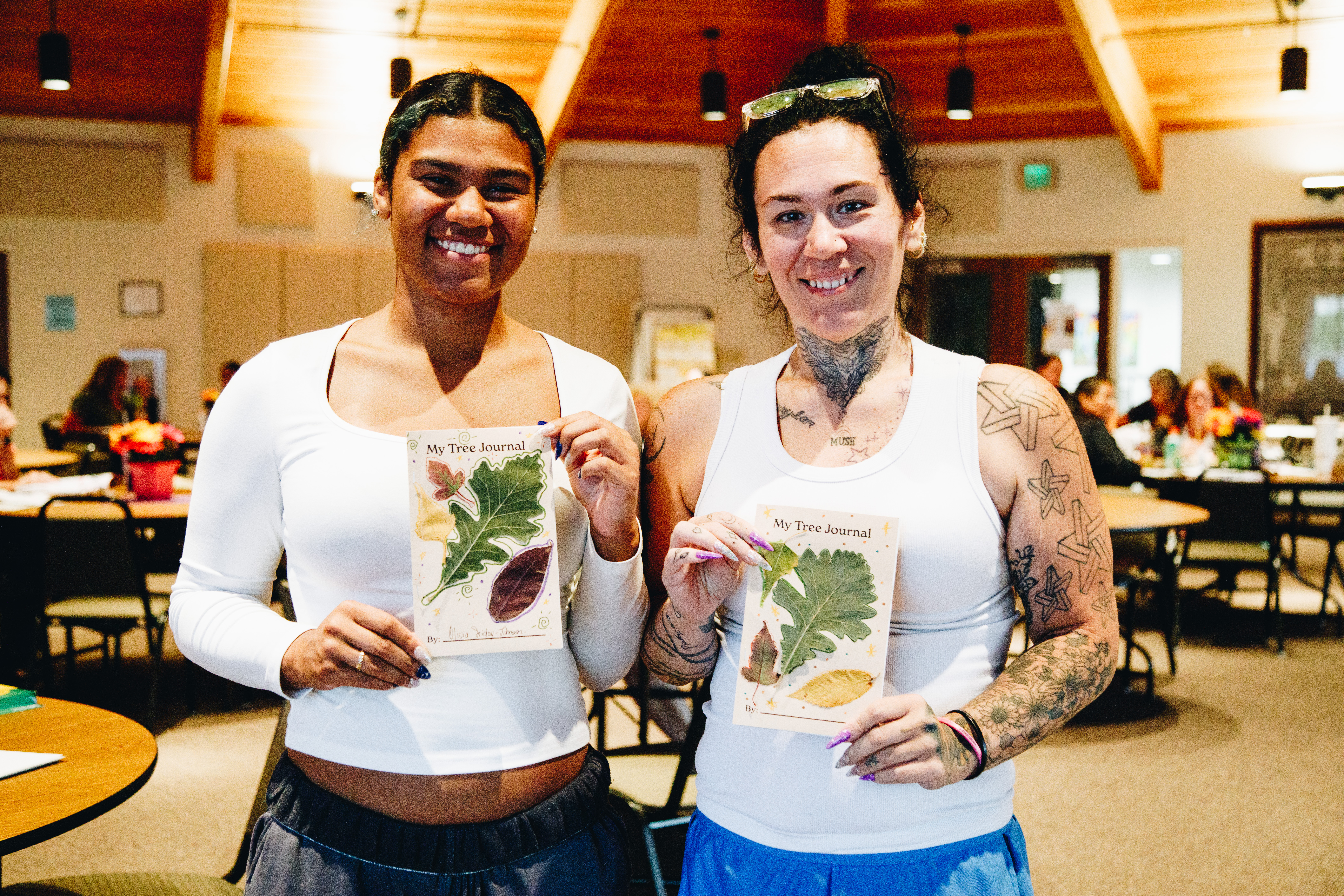 Two early childhood educators show off their tree journals.