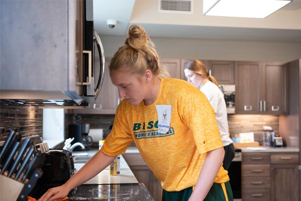 student volunteering cleaning stovetop