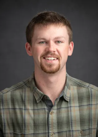 A man with a goatee smiling