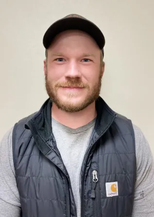 A man with a beard and a ball cap smiling