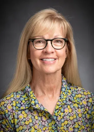 Polly Olson smiling confidently at the camera.