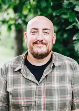 A man with a goatee smiling