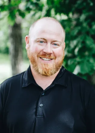 A man with a beard smiles