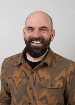 Josh Zeis looking confidently at the camera with a big smile.