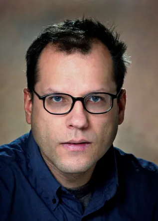 Uwe Burghaus smiling confidently at the camera