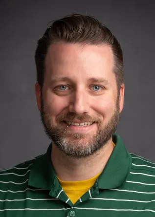 Travis Seaborn, PhD smiling confidently at camera.