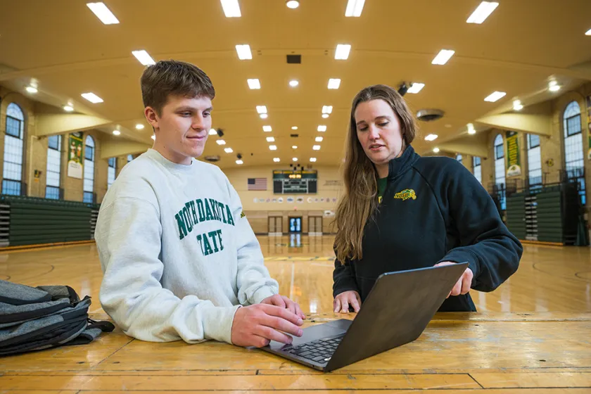 professor and student looking at a laptop