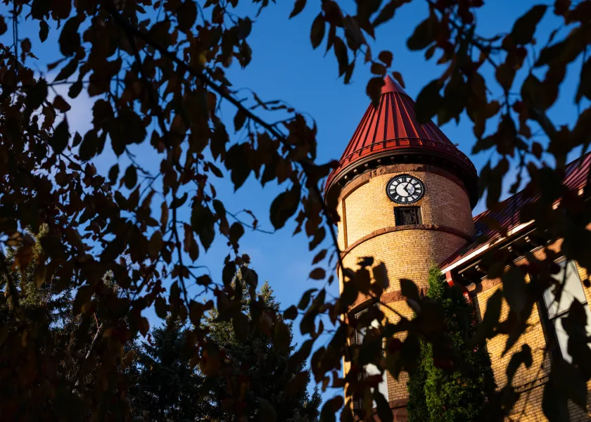 angled photo of the clock of Old Main against a deep blue sky