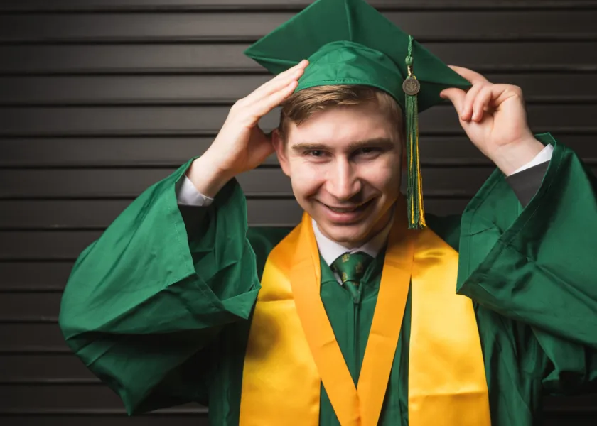 A photo of commencement speaker Simon Kroll in his cap and gown.