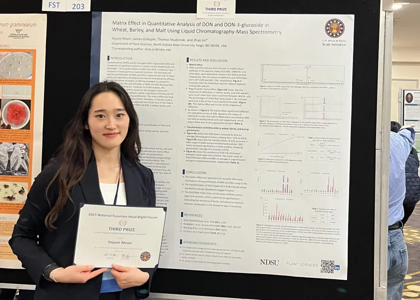 A photo of NDSU student YeJune Moon and her poster