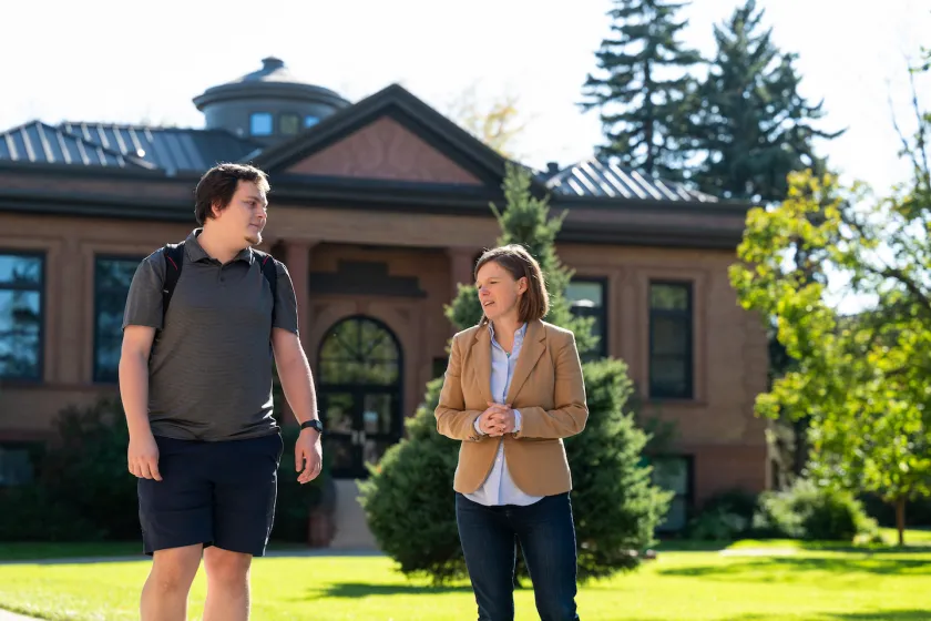student and professor walking on campus