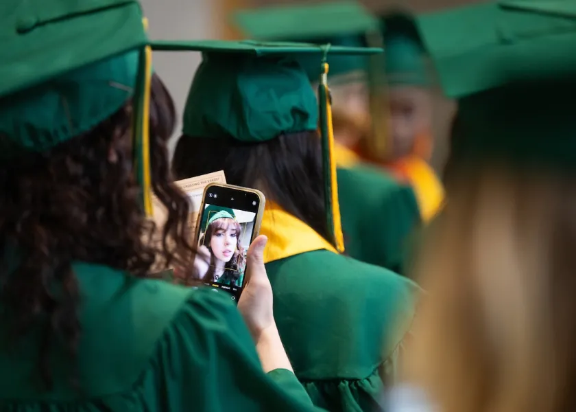 A student takes a selfie before commencement