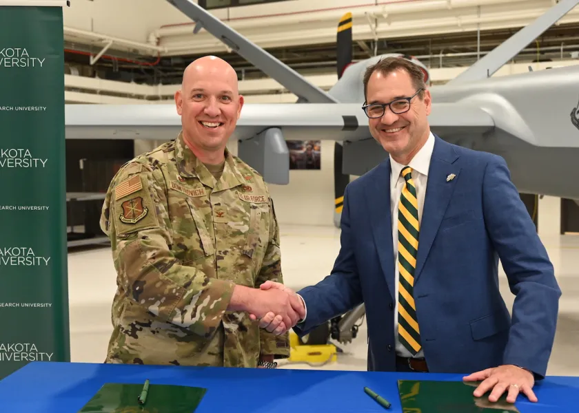 Col. Christopher Domitrovich and NDSU President David Cook shake hands after signing Memorandum of Agreement for student success