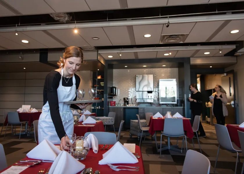 an NDSU student sets a table at 800 Café