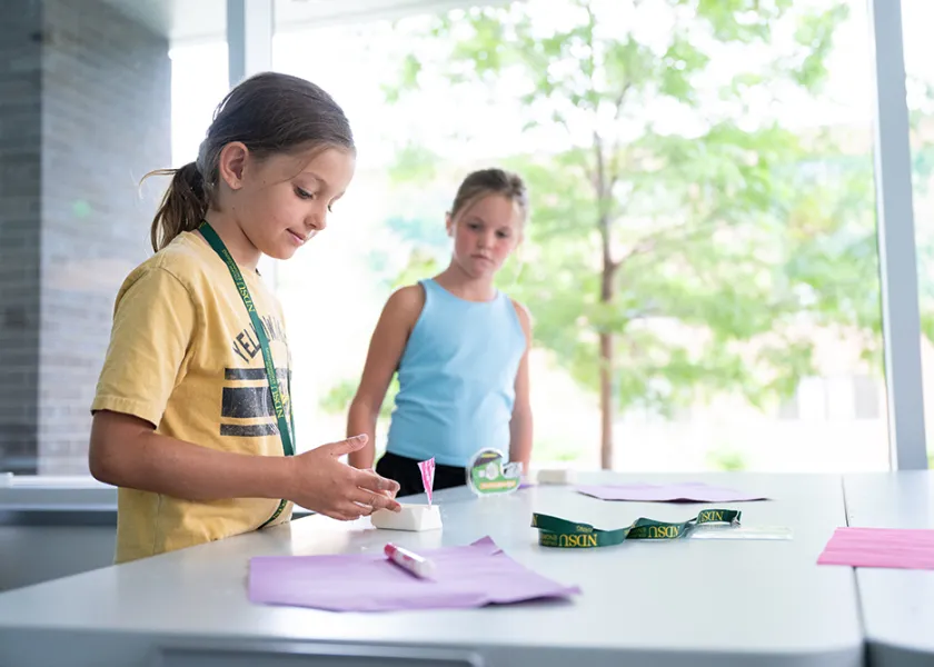Two young students working through a STEM experiment
