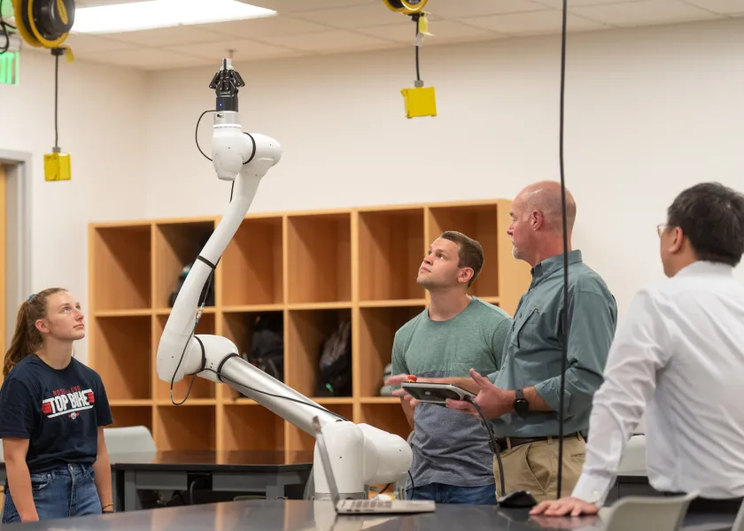 students working with a robot in a lab