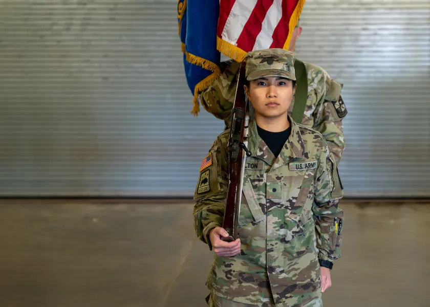student dressed in military uniform standing at attention