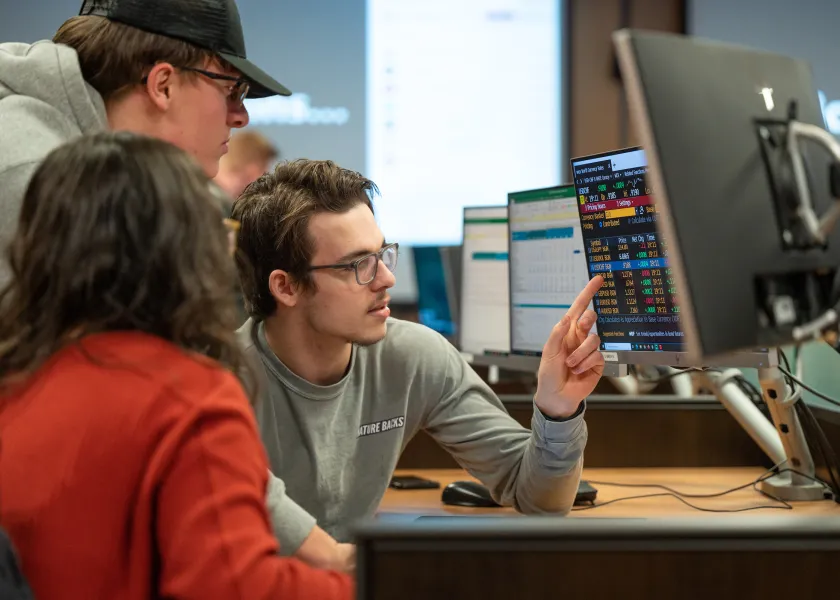 Students sitting at computer in commodity trading room.