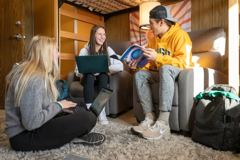 students smiling and talking in an NDSU residence hall