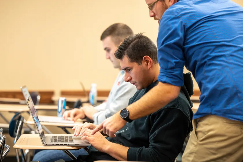 Sociology faculty helping a student during class