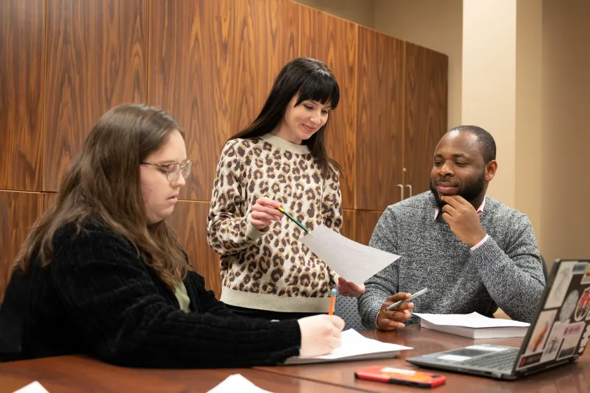 graduate students working on a project in a classroom