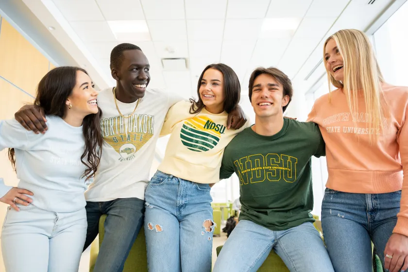 five students talking and laughing while wearing NDSU sweatshirts