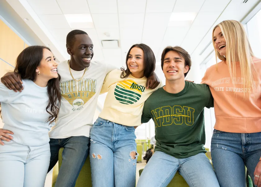 five students talking and laughing while wearing NDSU sweatshirts