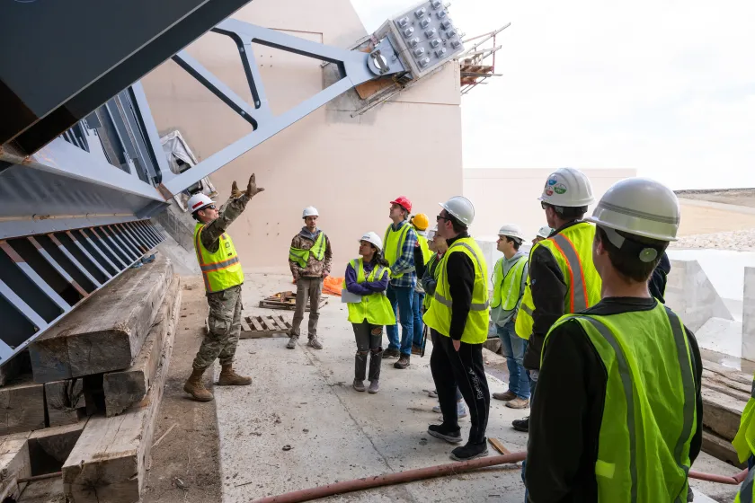 civil engineering students touring a construction site and listening to the foreman