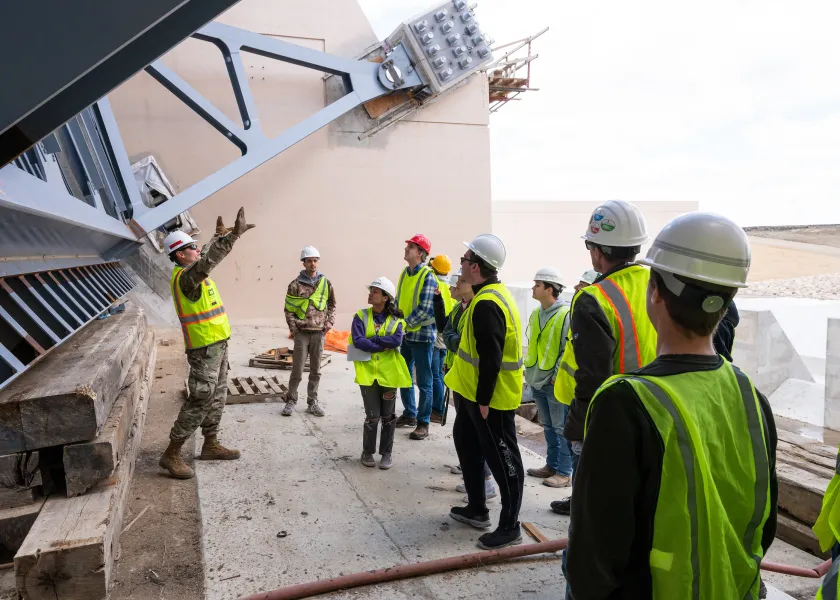 construction students touring a site and listening to an explanation by a construction worker