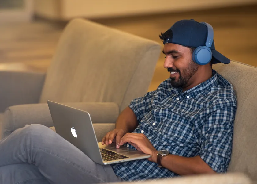 student working on laptop wearing headphones