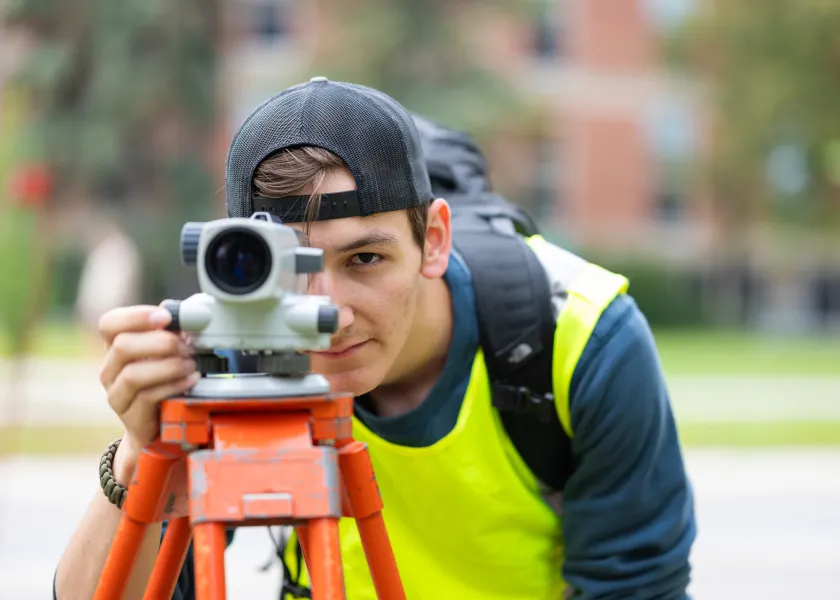 student using construction survey equipment