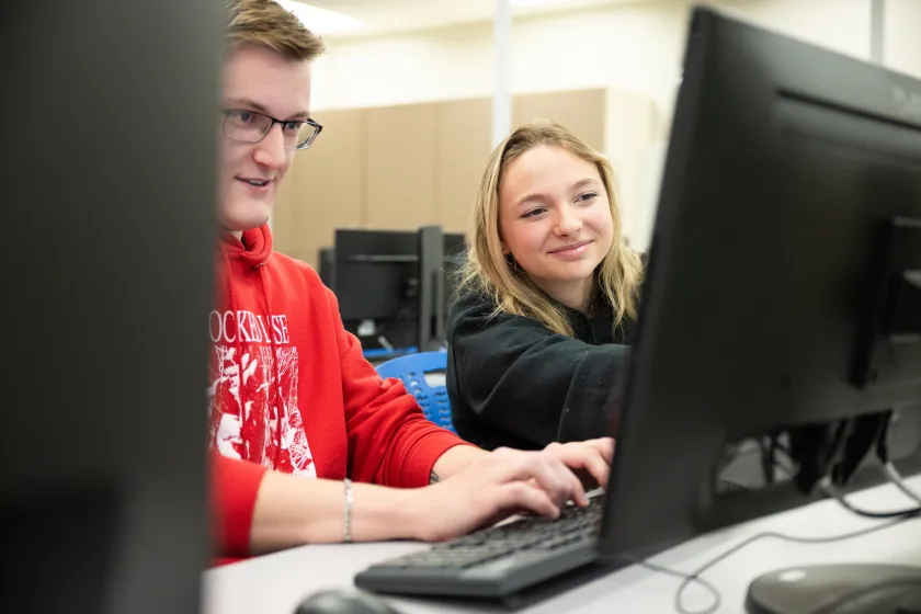 cybersecurity students working on a program in a lab