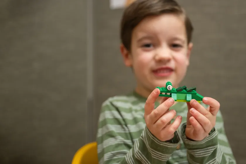 child holding up a Lego creation as part of Human Development and Family Science research