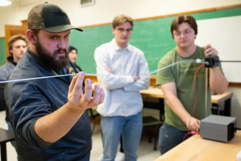 students performing a physics experiment in a classroom