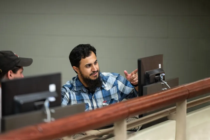 graduate students discussing a project in a computer lab