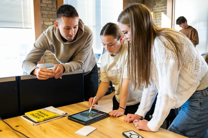 architecture students looking at a project on a tablet