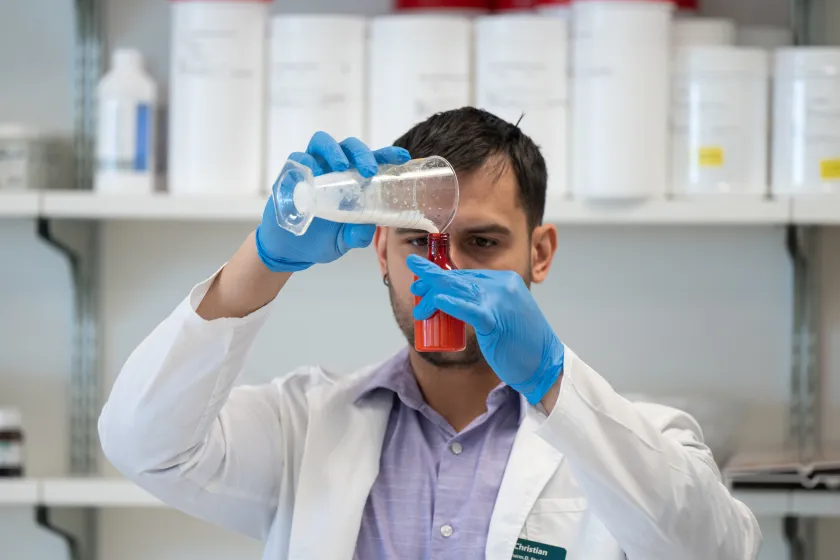 student measuring a substance in a beaker