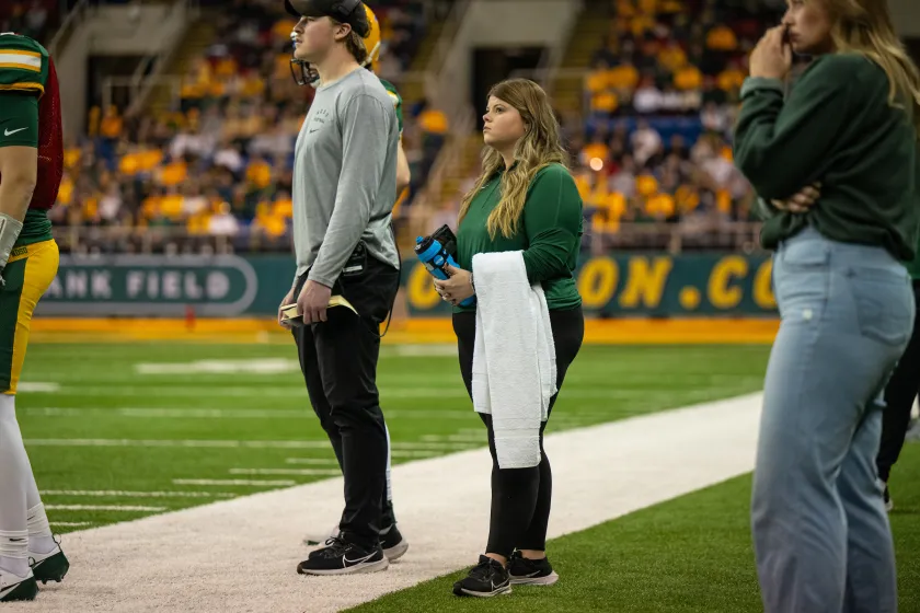 Sport Management students getting hands-on experience on the sideline of a football game