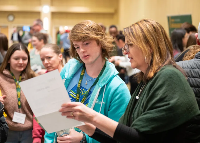 staff member helps student guest at discover days event