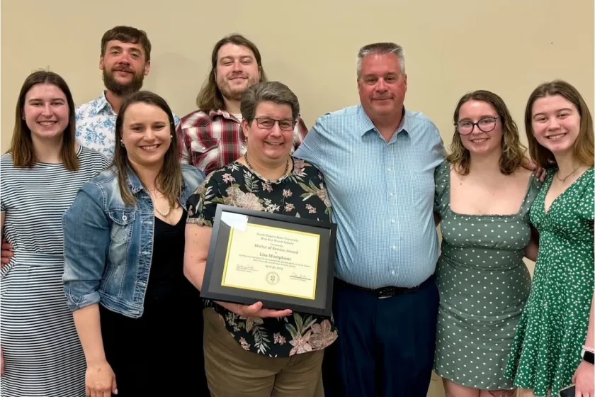 Lisa Montplaisir, NDSU professor of biological sciences, holding her award while standing with members of NDSU's Blue Key Honor Society