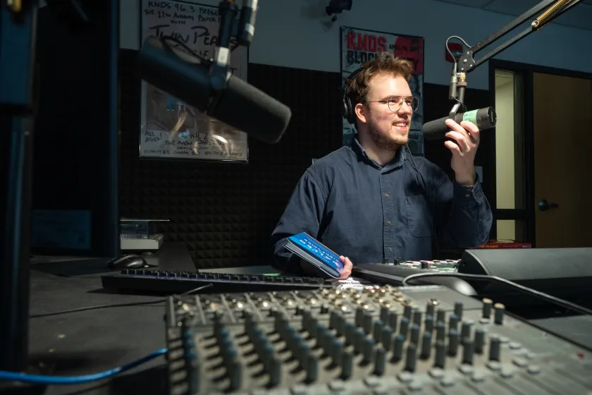 student running a podcast and working in the sound studio