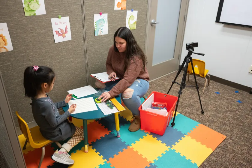 student working with young child in a human development and family science research lab