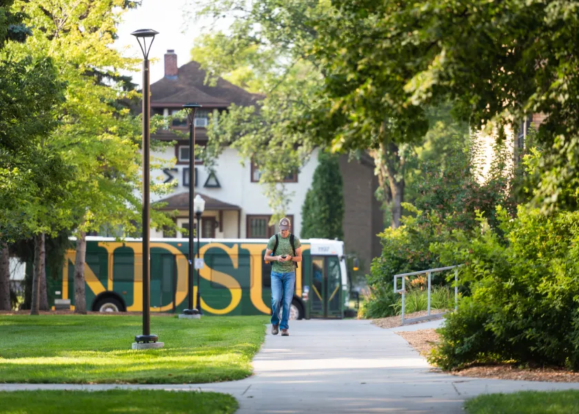 NDSU Bus and student walking