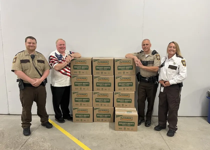 Tim Flakoll, NDSU Phi Kappa Phi chapter president and Cass County Commissioner, stands with boxes of books donated to the Clay County Jail.